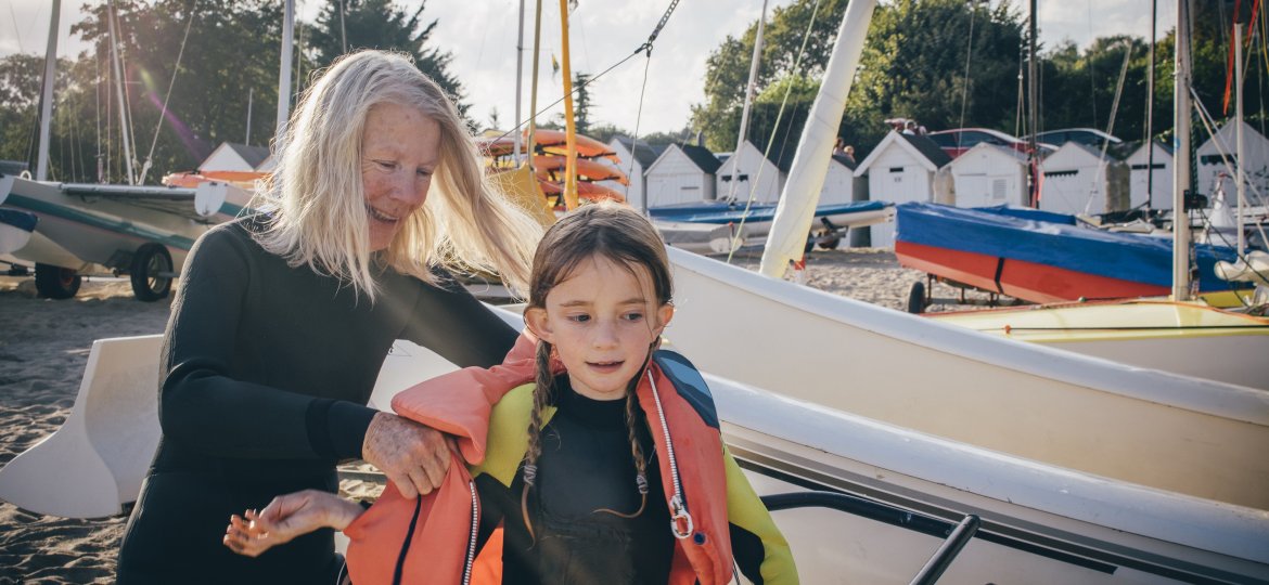 Grandmother Assists Child with Lifejacket